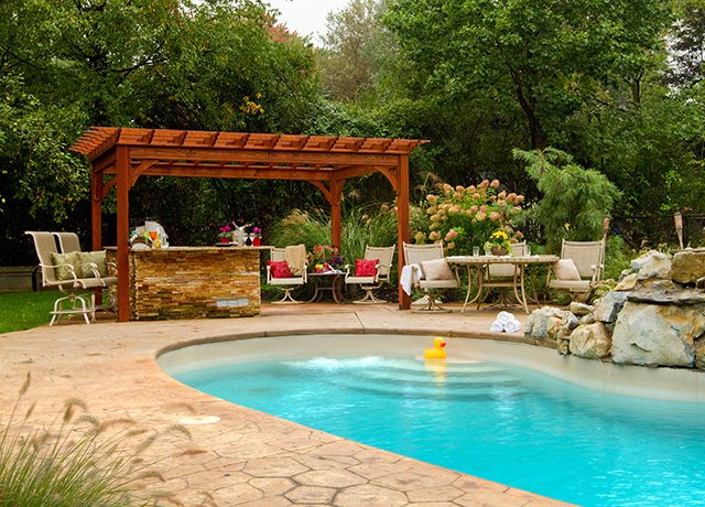 Wooden pergola with an inground pool and a yellow duck
