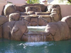 custom rock waterfall in a swimming pool