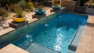 Resort-style backyard pool with tropical plants and lighting