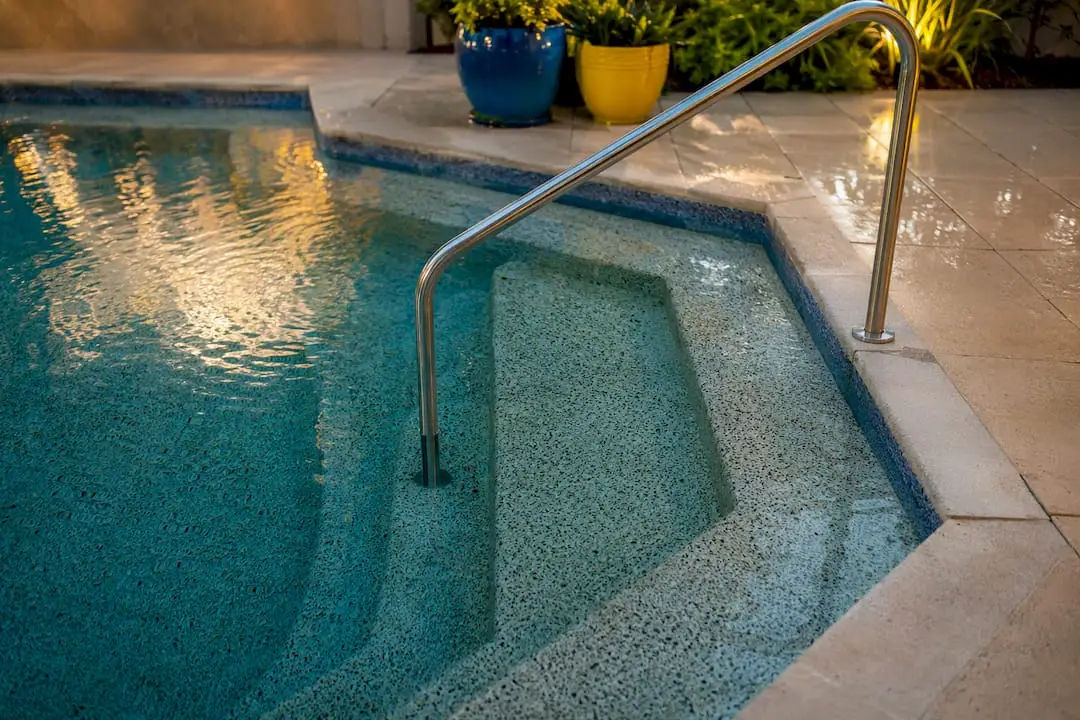 Corner angled pool entry steps with handrail