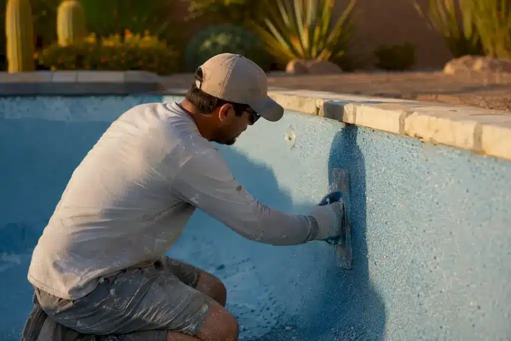 Technician smoothing pool resurfacing plaster