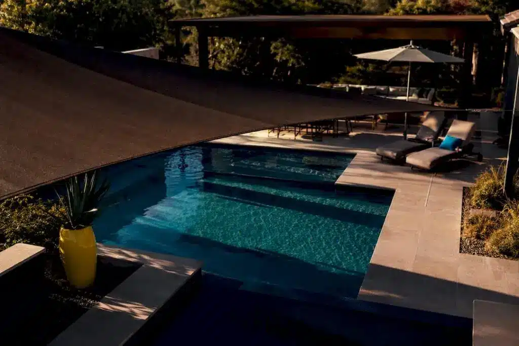 Layered shade structures over a backyard pool